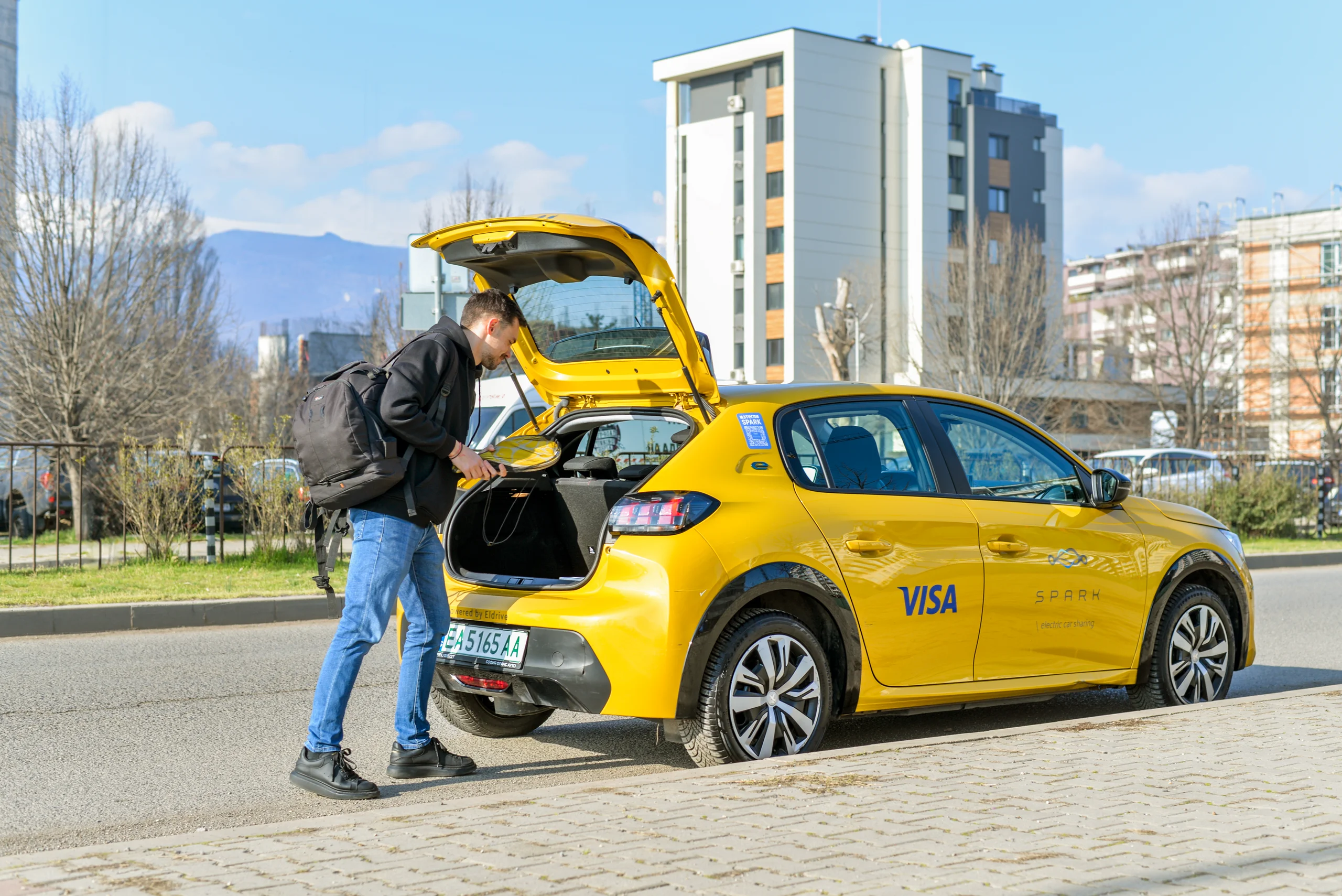 Жълто SPARK Peugeot 208, паркирано до кафене